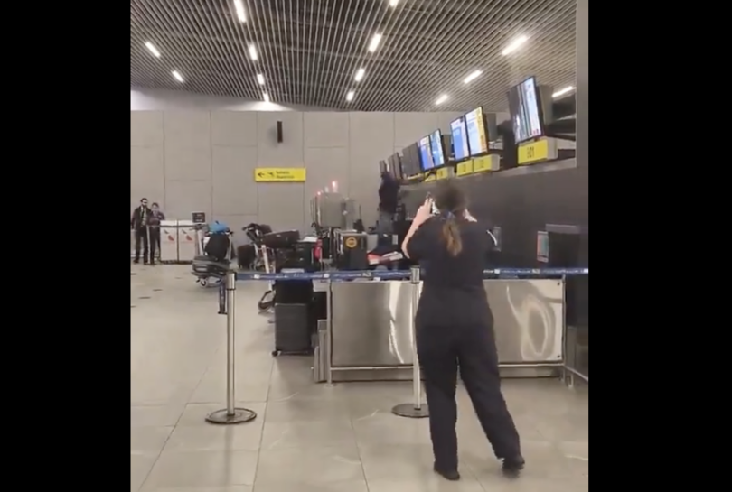 a woman standing in front of a counter with a few screens